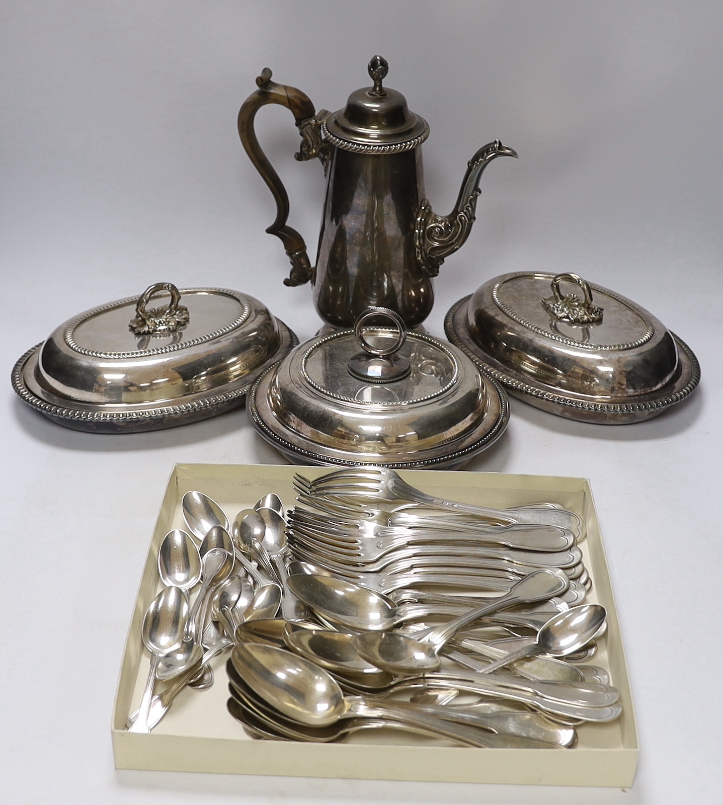 Assorted plated wares including Christofle flatware, coffee pot and three serving dishes.